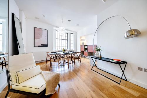 a living room with a table and chairs at Apt with Aircon 3 Bedr, 4 Beds, 2 Bath Trafalgar SQ in London
