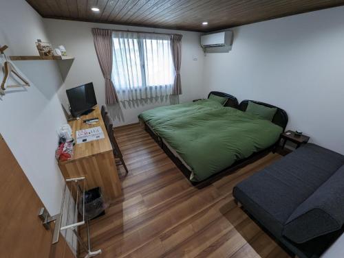 a bedroom with a green bed and a television at guest house Ki-zu - Vacation STAY 96116v in Nishio