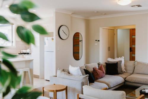 a living room with a couch and a clock on the wall at Riverlea at The Willows - A Family Country Getaway in Mudgee