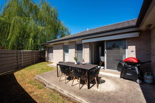 a patio with a grill and a table and chairs at Gladstone at The Willows - Family Time, Mudgee Style in Mudgee