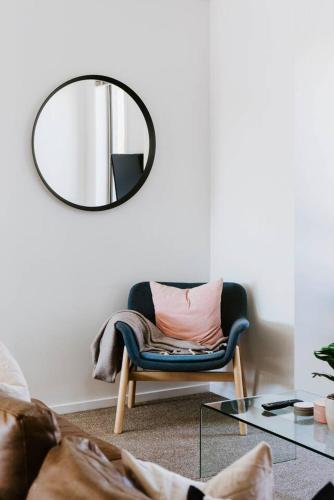 a living room with a chair and a mirror at Gladstone at The Willows - Family Time, Mudgee Style in Mudgee