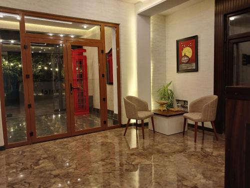 a lobby with a red phone booth and chairs at North Hotel in Qusar