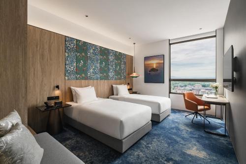 a hotel room with two beds and a couch at Crowne Plaza Penang Straits City by IHG in Perai