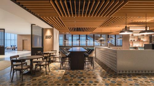 a restaurant with tables and chairs and a bar at Crowne Plaza Penang Straits City by IHG in Perai