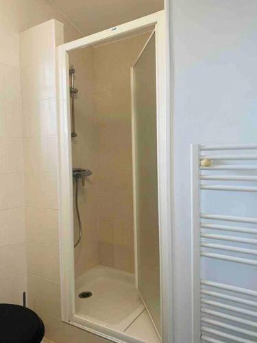 une douche avec une porte vitrée dans une salle de bain dans l'établissement Petit duplex Aéroport de Marseille et Plages, à Marignane
