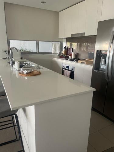 a kitchen with a white counter top and a refrigerator at Ocean view 2 Bedroom apartment in Sydney