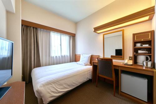 a hotel room with a bed and a desk at Daiichi Inn Ikebukuro in Tokyo