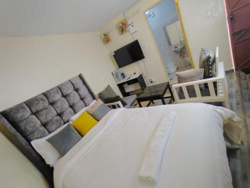 a bedroom with a large bed and a couch at Marvel Homes-Kivaa,Studio in Mavuria