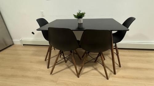 a black dining room table with four black chairs at New & Modern 2 bedroom suite in Surrey