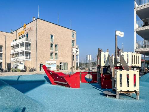 an empty playground in front of a building at Strandblick - Dorf 1 Ferienhaus 09 in Priwall