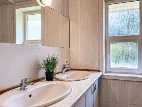 two sinks in a bathroom with two windows at Strandblick - Dorf 1 Ferienhaus 21 in Priwall