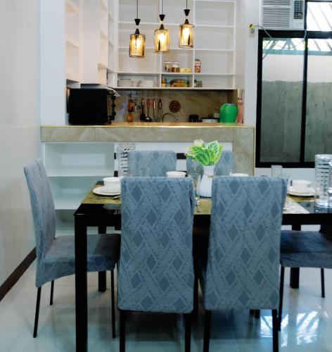 a dining room with a black table and blue chairs at Rb's Three Storey House in Zamboanga