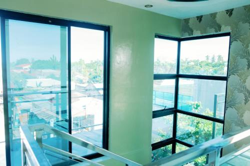 an empty room with windows and a staircase at Rb's Three Storey House in Zamboanga