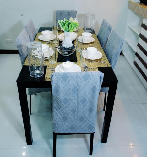 a dining room table with blue chairs and a black table at Rb's Three Storey House in Zamboanga