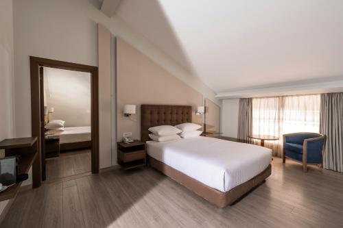 a bedroom with a bed and a desk and a mirror at InterContinental Mzaar Lebanon Mountain Resort & Spa by IHG in Kfardebian