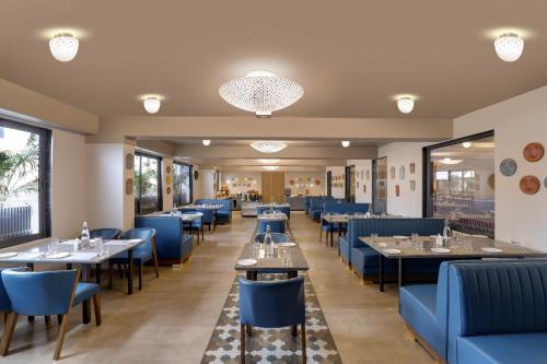 Un comedor con mesas y sillas azules. en Keys Lite by Lemon Tree Hotels, Vadodara, en Vadodara