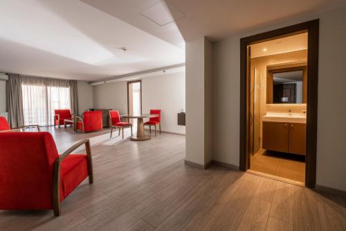 a living room with a table and red chairs at InterContinental Mzaar Lebanon Mountain Resort & Spa by IHG in Kfardebian