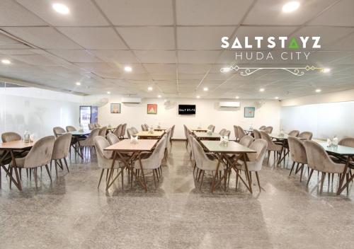 a restaurant with tables and chairs in a room at Saltstayz Select - Near Millennium City Centre in Gurgaon