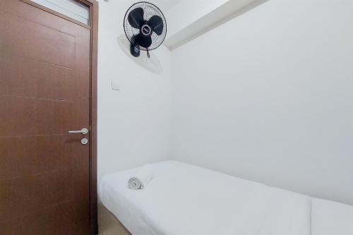 a bathroom with a toilet next to a door at Homey and Modern 2BR at Loftvilles City Apartment By Travelio in Tangerang