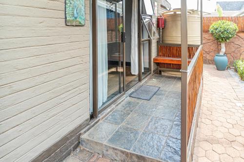 a door to a house with a bench next to it at Gold Crest Guesthouse in Roodepoort