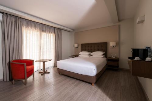 a hotel room with a bed and a red chair at InterContinental Mzaar Lebanon Mountain Resort & Spa by IHG in Kfardebian