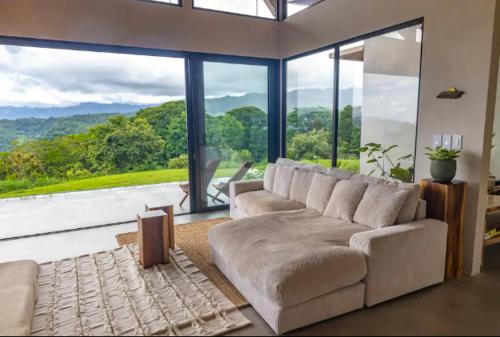 a living room with a couch and a large window at The Oasis, Jungle Sanctuary in Barú