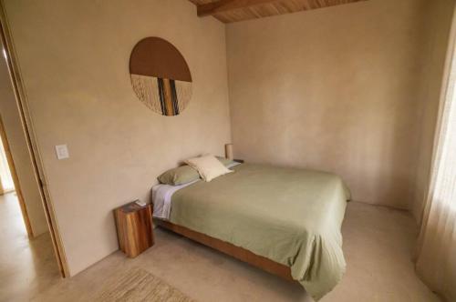 a bedroom with a bed and a round mirror at The Oasis, Jungle Sanctuary in Barú