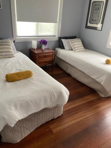 a room with two beds and a table with flowers at Bird Song Farm in Hat Head