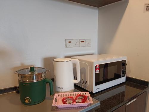 a kitchen counter with a microwave and a coffee maker at Landmark Million Dollar King Suite #Netflix#500mbps WiFi in Tanjong Tokong