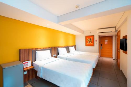 Una cama o camas en una habitación de Swiss-Belexpress Kuta Legian