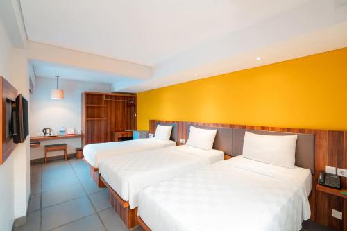 Una cama o camas en una habitación de Swiss-Belexpress Kuta Legian