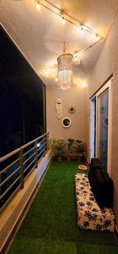 a room with a balcony with a couch and grass at Boho 44 in Goa