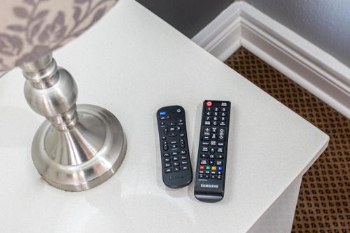 two remote controls sitting on a white table at Gold Crest Guesthouse in Roodepoort