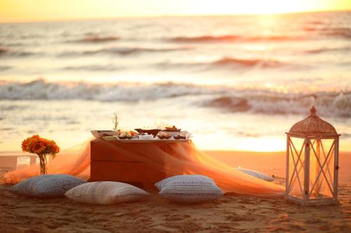 a table on the beach next to the ocean at Marbella Beach Hotel in Golem