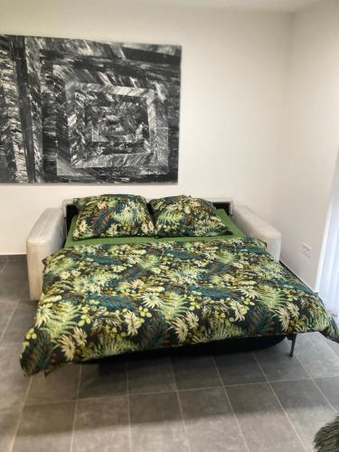 a bedroom with a bed with a green comforter at Swiss Star Apartment in Mosonmagyaróvár