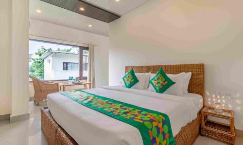 a bedroom with a large bed and a large window at Treebo Tiger Pug Mark Resort with Pool in Rāmnagar