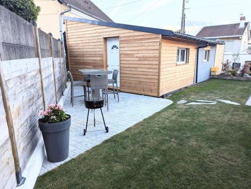 a patio with a table and chairs in a backyard at maisonnette au calme, proche CDG, Parc Expo, Arena in Villepinte