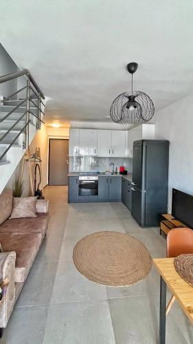 un soggiorno con divano e cucina di Granari Luxury Maisonette Nikiti a Nikiti