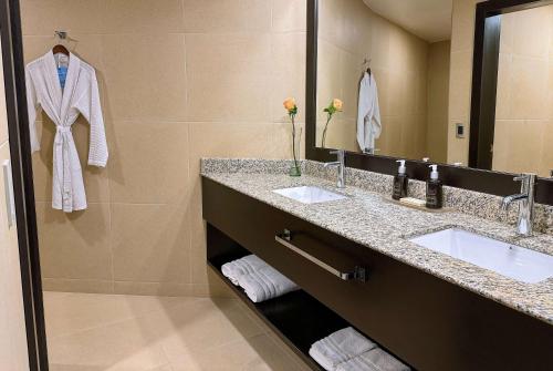 a bathroom with two sinks and a large mirror at Wyndham Quito Airport in Tababela