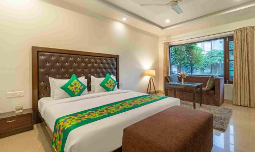 a bedroom with a large bed and a large window at Treebo Tiger Pug Mark Resort with Pool in Rāmnagar