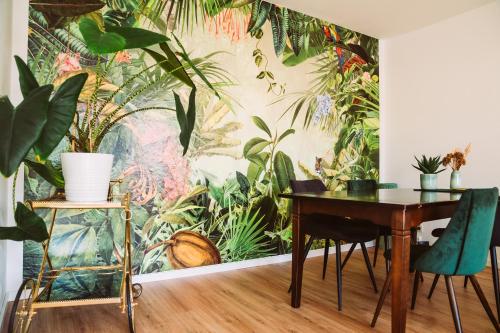 a dining room with a wall mural of plants at Dschungel in BaLi 72qm Ferienwohnung im Zentrum in Bad Lippspringe