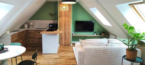 un salon avec un canapé et une cuisine dans l'établissement CITY HÔTE appartement centre ville au calme vue sur le château, à Vitré