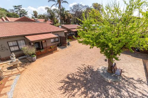 an empty courtyard with a tree and a building at Gold Crest Guesthouse in Roodepoort
