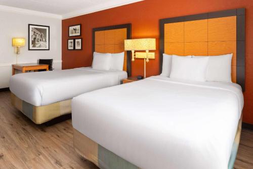 una camera d'albergo con due letti e una scrivania di La Quinta Inn by Wyndham Pittsburgh Airport a Moon Township