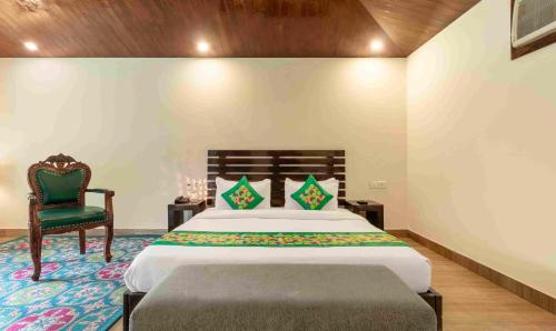 a bedroom with a bed and a chair at Treebo Tiger Pug Mark Resort with Pool in Rāmnagar