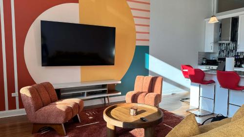 a living room with a tv and chairs at Chic 2 BR 1 Parking Sleeps 6 in Chicago