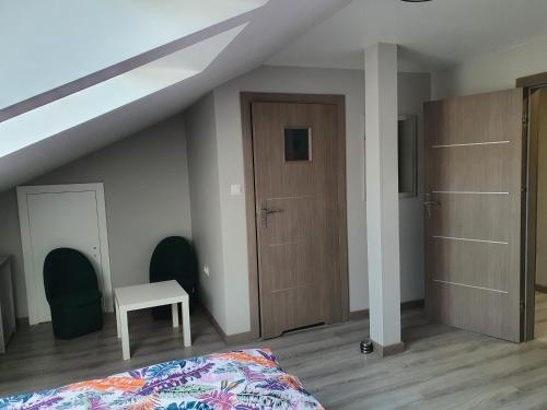 a bedroom with a bed and a wooden door at Stajnia Kruki in Mrozy