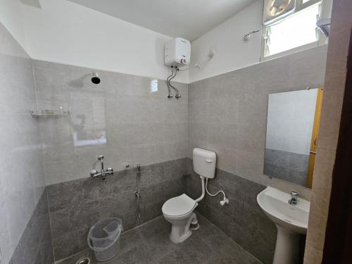 a bathroom with a toilet and a sink at Maya Homes in Puri