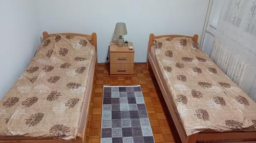 Dos camas una al lado de la otra en una habitación. en RelaX, en Kula