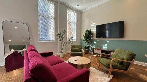 a living room with a purple couch and chairs at Cozy 1 BR 1 Parking Sleeps 4 in Chicago
